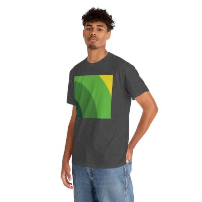 A person stands casually with one hand on their hip, wearing a dark grey T-shirt featuring a bold green graphic. The design consists of overlapping arc-like shapes in varying shades of green, creating a layered, concentric pattern. A small green ribbon symbol is placed in the bottom left corner of the graphic. The contrast between the orange shirt and green design makes the artwork visually striking, while the ribbon may suggest support or awareness for a cause. The person is smiling and looking slightl