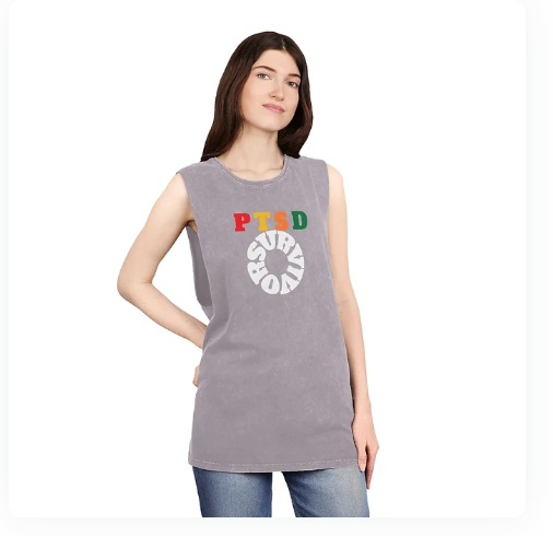 A person wears a sleeveless gray shirt with the phrase "PTSD SURVIVOR" printed on the front. The letters "PTSD" are bold and individually colored—"P" in red, "T" in yellow, "S" in green, and "D" in orange—while "SURVIVOR" is displayed in white, arranged in a circular pattern below. The design conveys a powerful message of resilience and awareness, blending bold typography with symbolic color to honor the strength of those living with or recovering from PTSD.