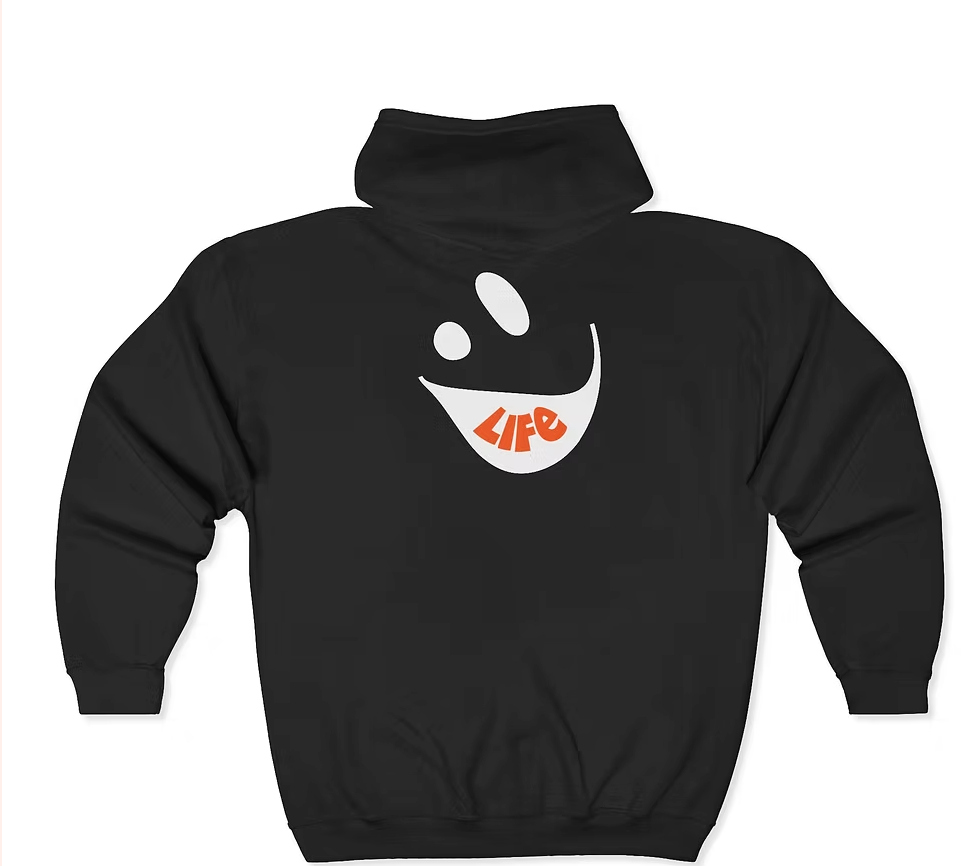 The back of a black hoodie features a large stylized smiling face with two white oval eyes and a wide curved white mouth. Inside the mouth, the word “LIFE” is printed in bold red uppercase letters. The design is minimal yet expressive, blending playful energy with a motivational message that celebrates joy, vitality, and emotional resilience.