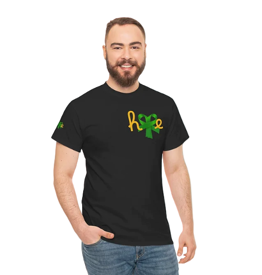 A person wears a black t-shirt featuring the word “hope” in a stylized design. The letters “h,” “o,” and “e” are rendered in yellow-orange script, while the “p” is creatively replaced with a green awareness ribbon. A smaller green ribbon also appears on the left sleeve. The design evokes encouragement and mental health advocacy, blending warmth with symbolic strength.