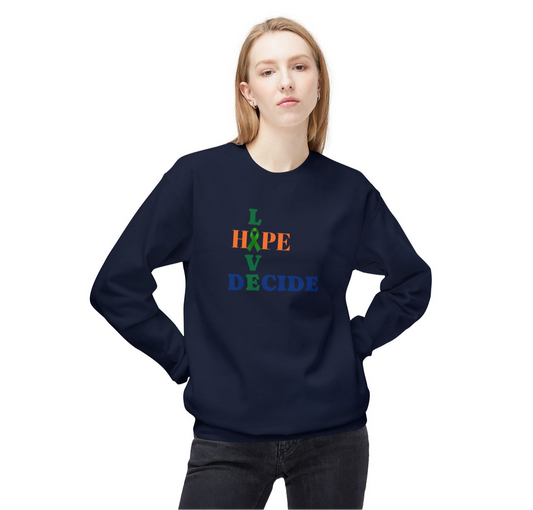 A person wears a dark sweatshirt with a vertically stacked multicolored text design. The letters read “L,” “H🧩PE,” “V,” and “DECIDE.” “L” and “V” are green, “H🧩PE” is orange with a green puzzle piece replacing the “O,” and “DECIDE” is blue. The design blends advocacy with emotional depth, suggesting themes of love, hope, choice, and autism awareness.