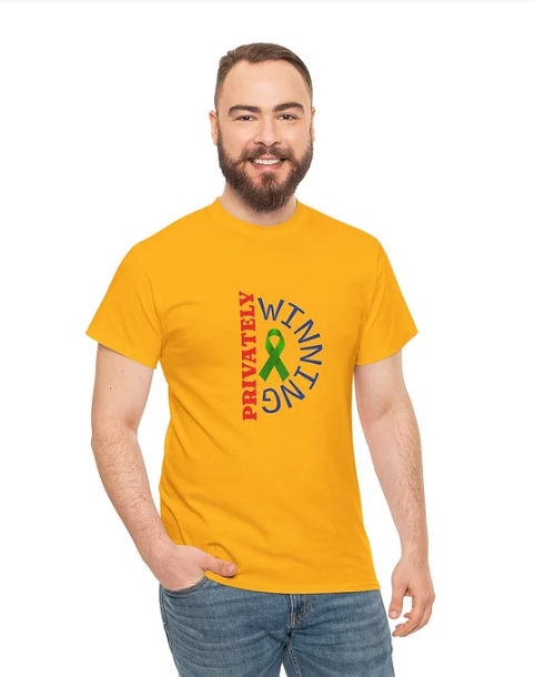 A person wearing a bright yellow T‑shirt with a graphic design on the front. The design features the word “PRIVATELY” in red, printed vertically on the left, and the word “WITHIN” in blue, printed vertically on the right. Between them is a green ribbon‑like symbol resembling an ampersand.