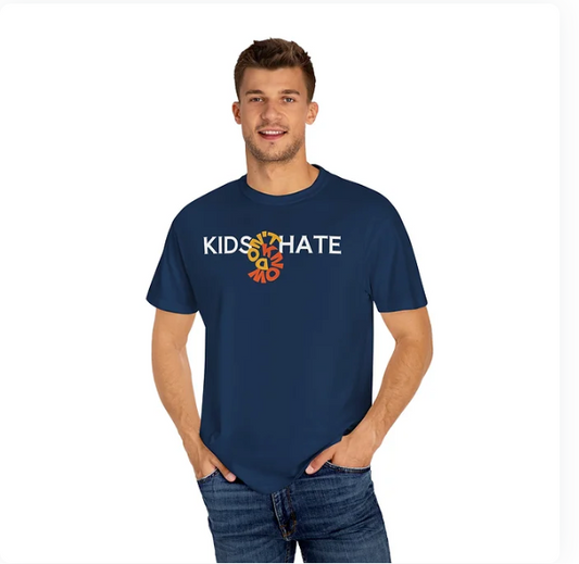 A man wears a navy blue T-shirt with the phrase "KIDS THAT HATE" printed across the chest. At the center of the phrase, a stylized circular graphic replaces the word "LOVE"—the letters "L", "O", "V", and "E" arranged in a spiral pattern. This visual interruption adds a creative twist to the message, blending bold typography with abstract design. The shirt invites interpretation, making it a compelling piece for expressive or thought-provoking fashion.